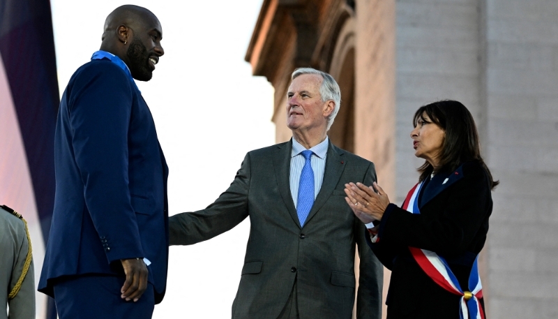 Le premier ministre Michel Barnier et la maire de Paris Anne Hidalgo en compagnie du médaillé olympique Teddy Riner, le 14 septembre 2024.