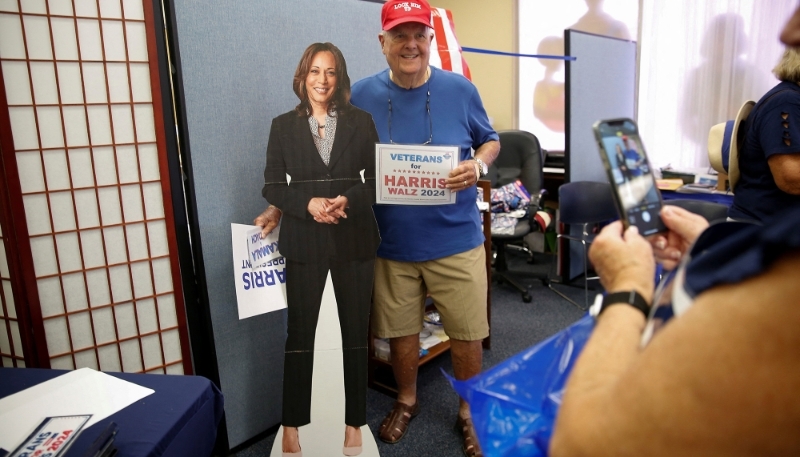 Un vétéran de l'armée américaine pose avec une photo de la candidate démocrate à la présidentielle Kamala Harris en Floride, le 18 août 2024.